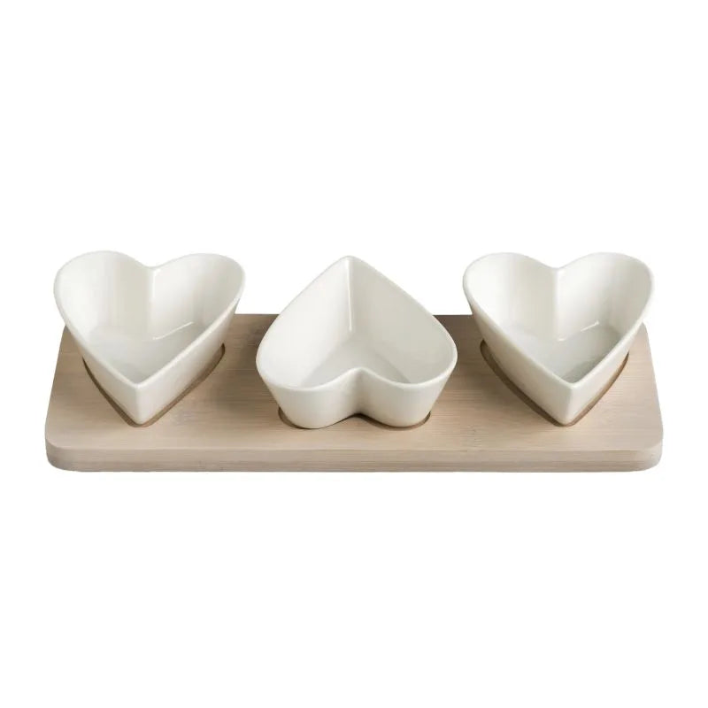 Bandeja de porcelana blanca con tres corazones y base de bambú natural.