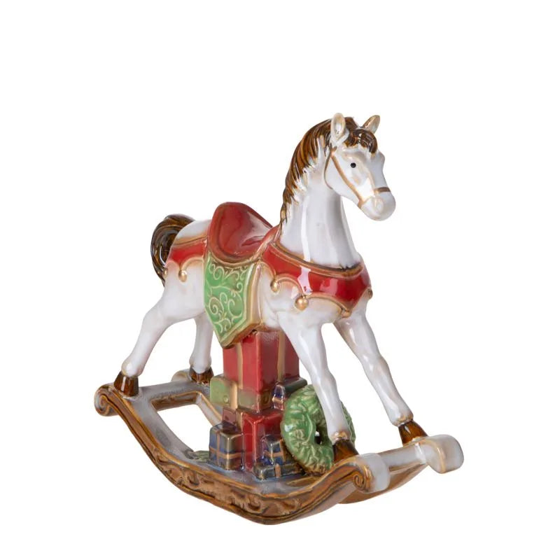Caballito de balancín decorativo de cerámica blanca con detalles pintados, sobre un fondo neutro.