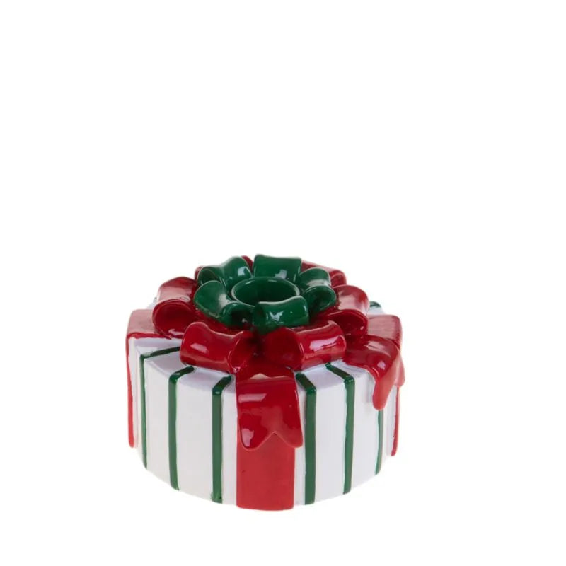 Candelero con forma de muñeco de nieve, de cerámica blanca, con detalles pintados en rojo y negro, y una bufanda verde.