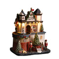 Castillo navideño decorativo con luces LED, música y movimiento en primer plano.