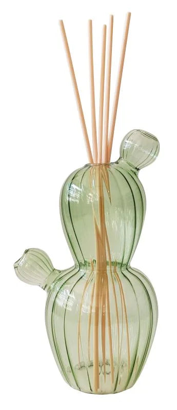 Difusor de fragancia con forma de cactus en color verde, con varios mikados insertados, presentado sobre un fondo neutro.