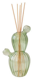 Difusor de fragancia con forma de cactus en color verde, con varios mikados insertados, presentado sobre un fondo neutro.