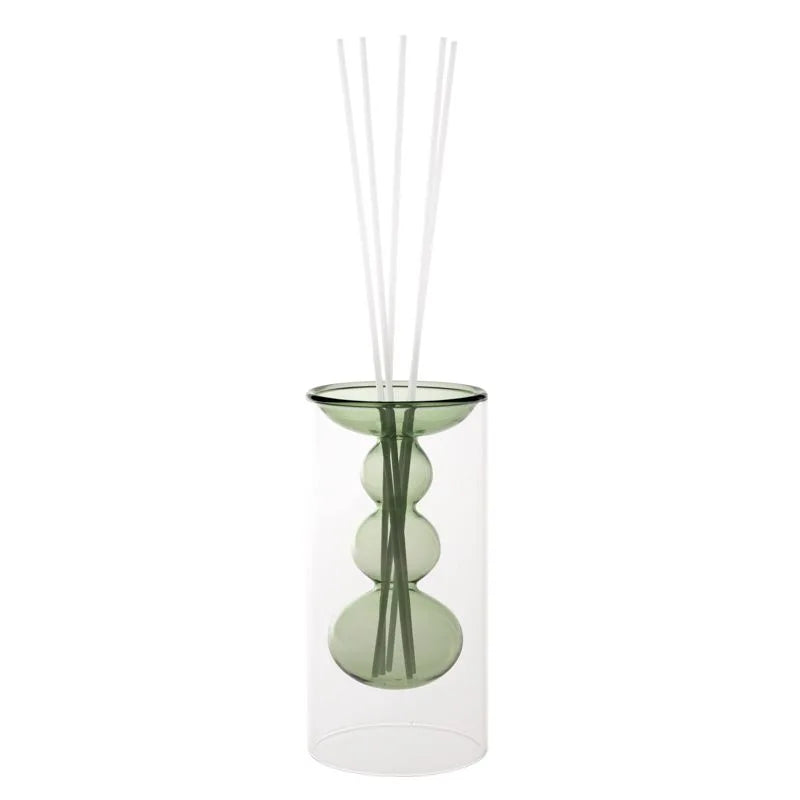 Difusor de fragancia Silhouette en color verde, con base y varillas decorativas.