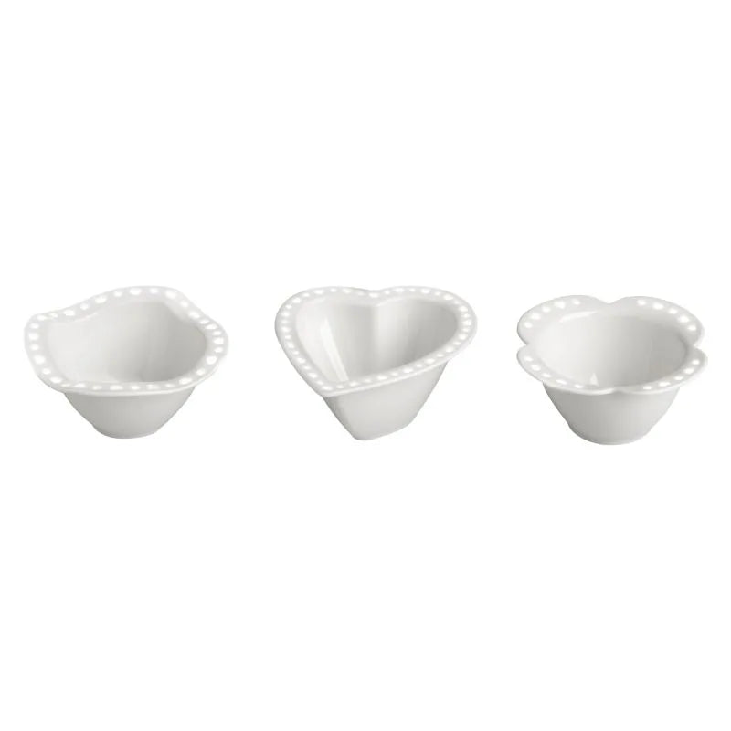 Packshot de 36 platos de porcelana blanca con borde perforado, presentados en un expositor.