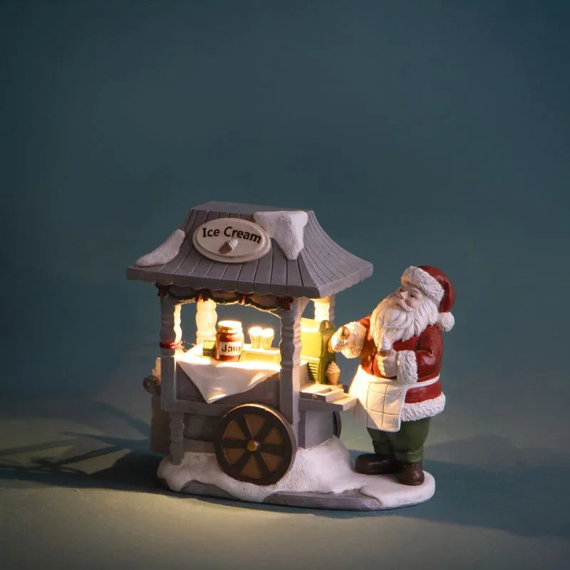 Figura decorativa de Papá Noel con un carro de helados iluminado con LED, con dimensiones de 15 x 8 x 14 cm.