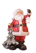 Figura decorativa de Papá Noel con un árbol y detalles LED, representando la colección navideña de Brandani.