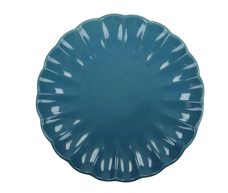 Plato llano de cerámica azul de la colección Calipso, con el logo de Brandani.