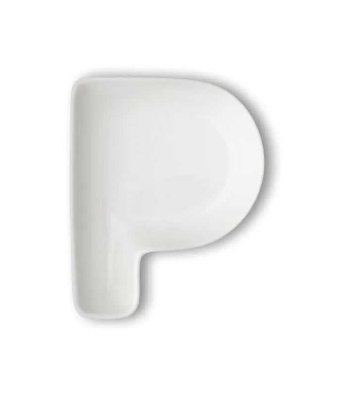 Letra 'P' de porcelana blanca sobre fondo neutro, mostrando su diseño italiano.