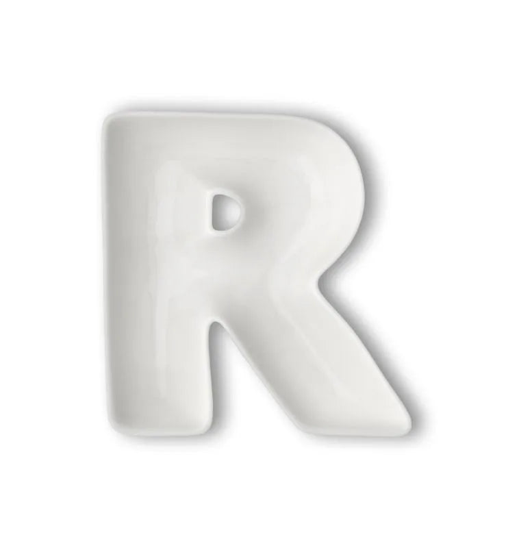 Letra decorativa 'R' de porcelana blanca sobre fondo neutro.