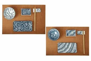 Set de 12 piezas para sushi, compuesto por platos de porcelana blanca y soportes de bambú natural, presentados de forma.