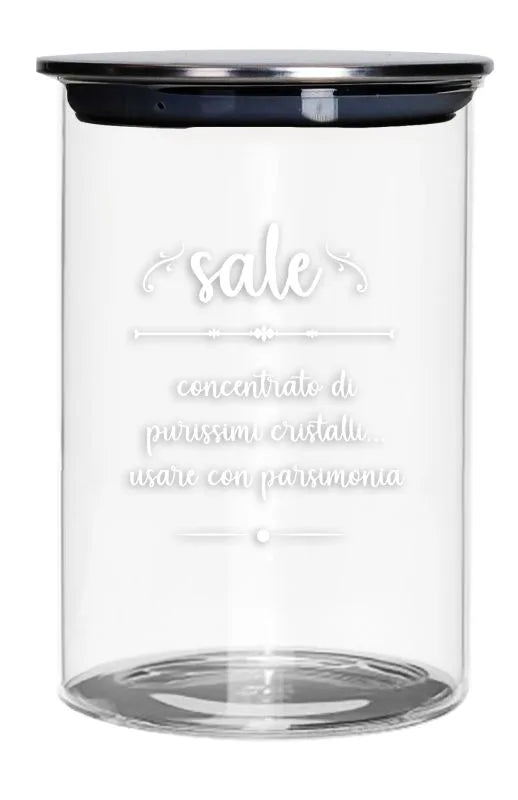 Tarro de cristal transparente para sal con una tapa metálica plateada, presentado sobre un fondo blanco.