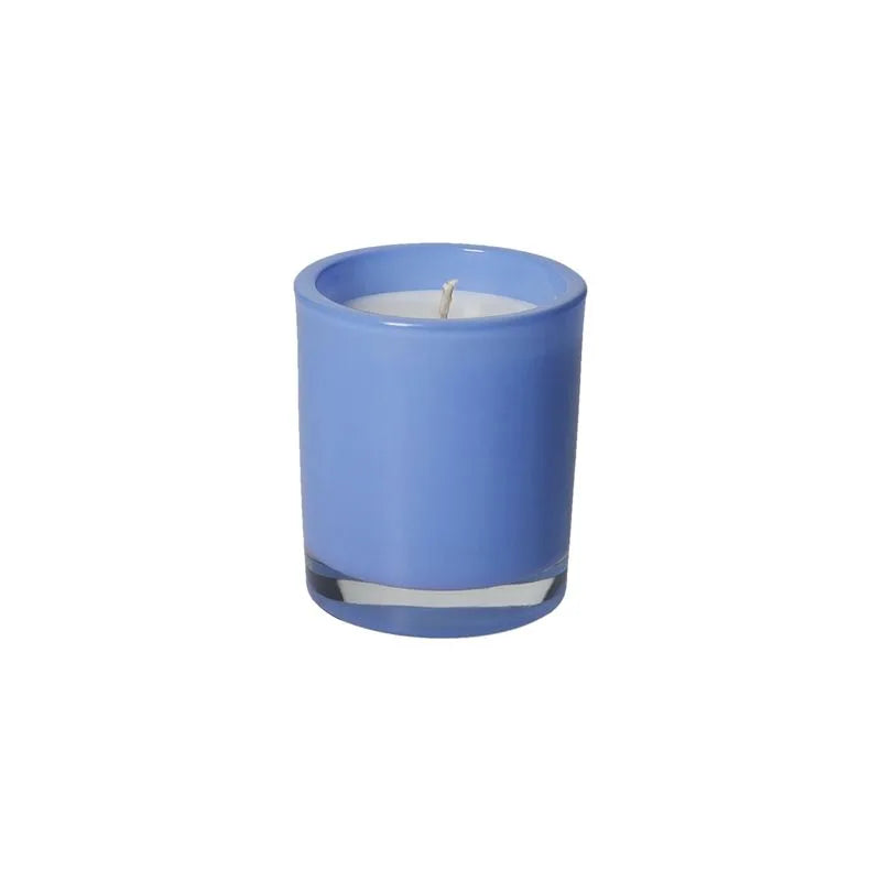 Vela perfumada de color azul con tapa, emitiendo un suave aroma a bergamota, presentada como un elemento decorativo.