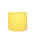 Vela perfumada de 3 mechas en recipiente de cristal amarillo, con cera de soja y aroma a limón.