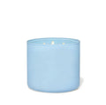 Vela perfumada azul de 3 mechas con cera de soja y esencia de bergamota en recipiente de cristal.