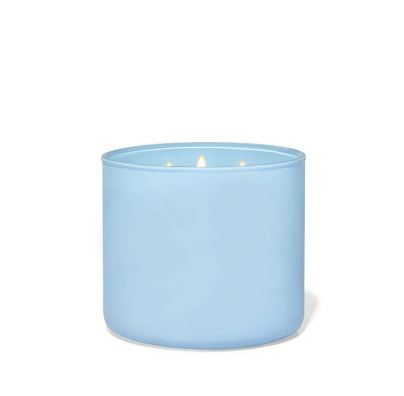 Vela perfumada azul de 3 mechas con cera de soja y esencia de bergamota en recipiente de cristal.